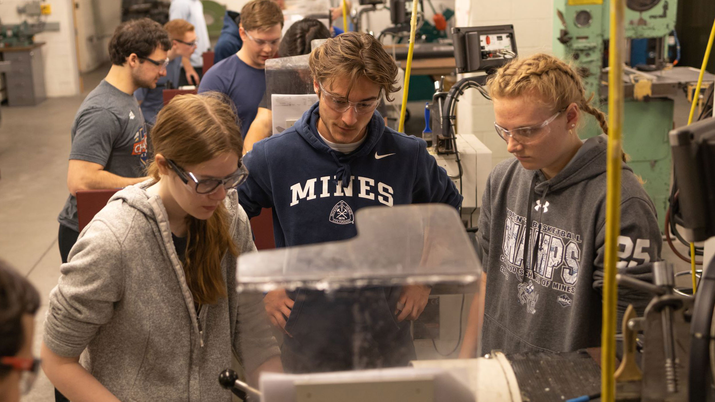 Mechanical Engineering students collaborating in a workshop with machinery