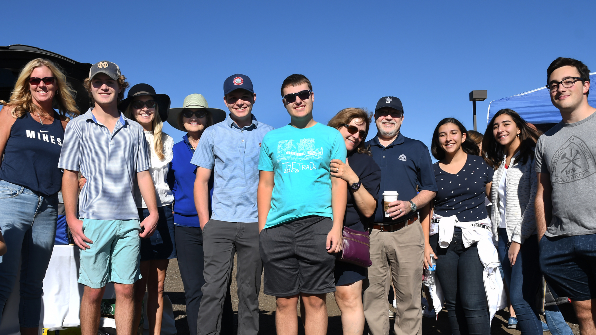 Families pose with their students at a family weekend tailgate