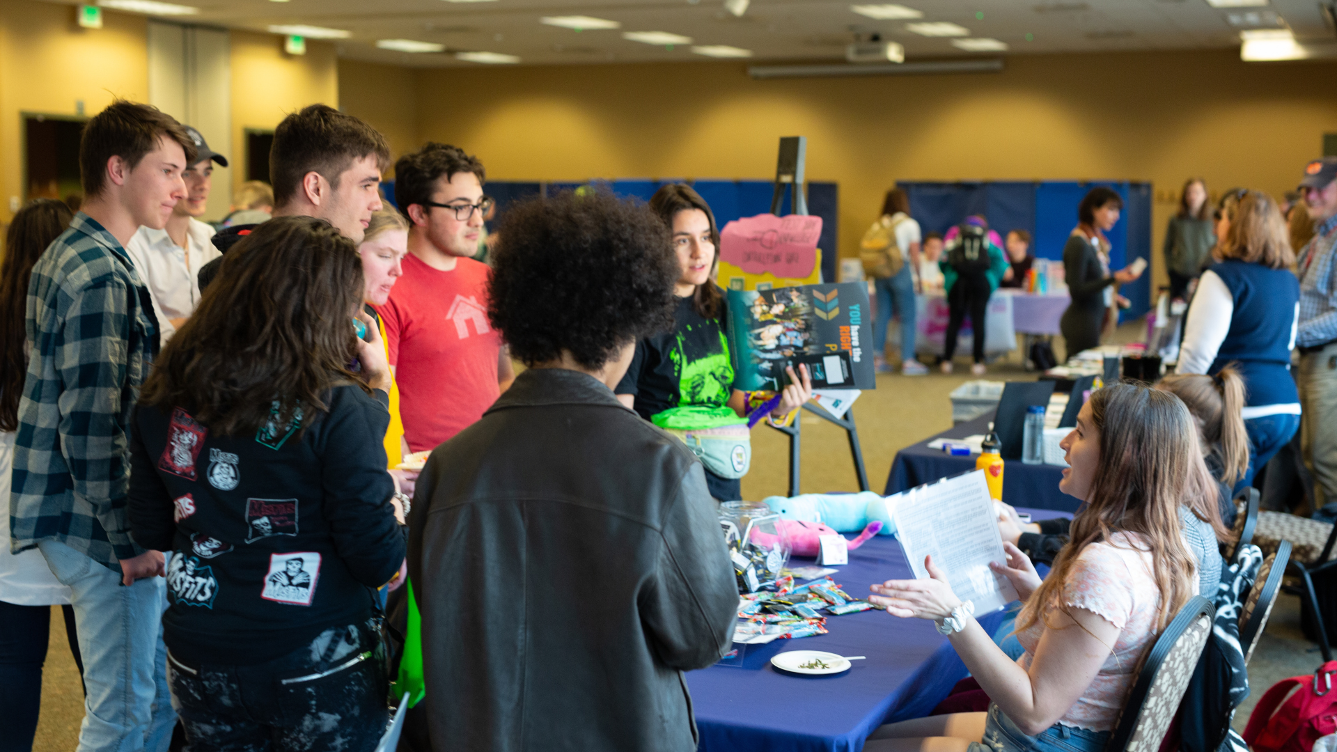 Students get information from a table at a student health event