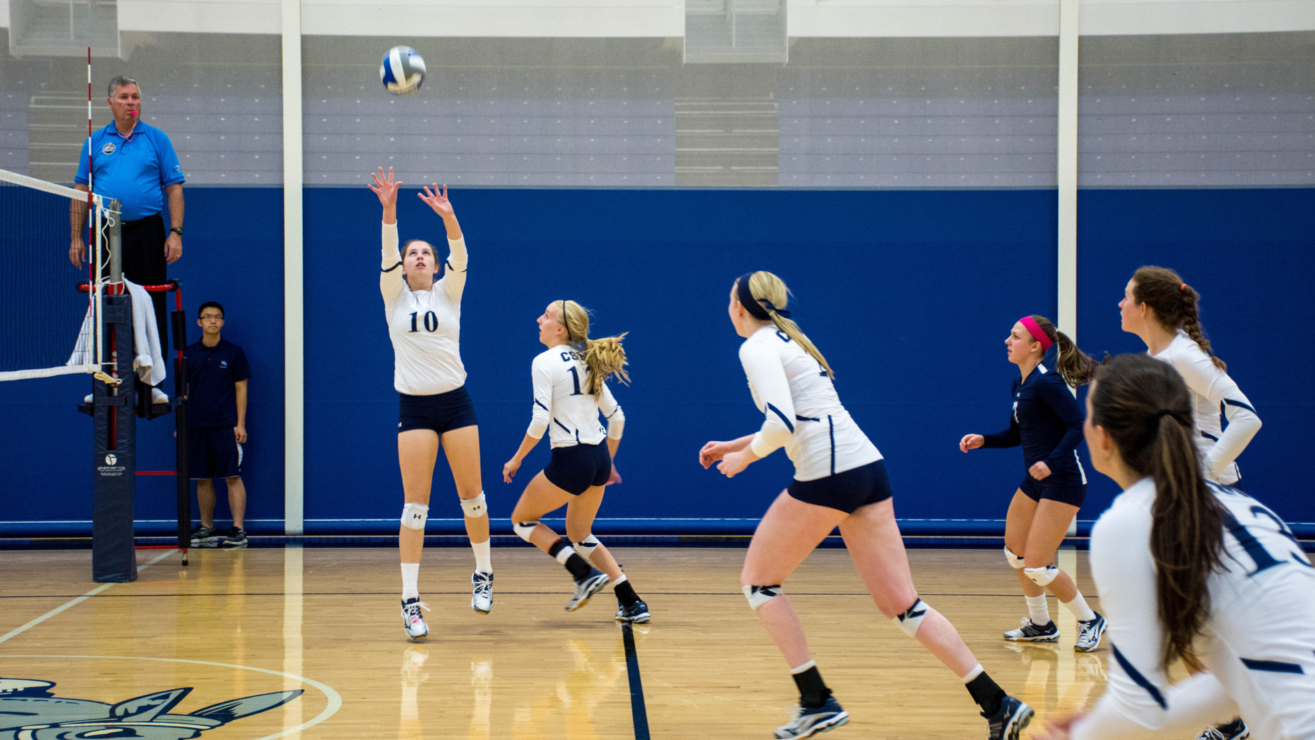 A player sets up a spike at a women's volleyball game